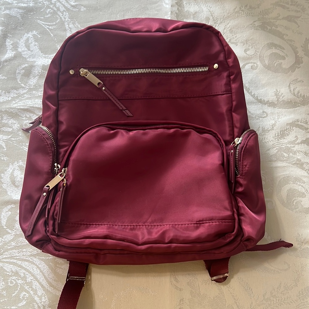 Dark red backpack with gold zippers